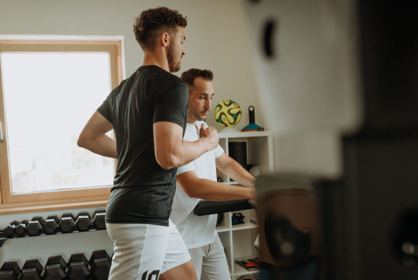 PhysJO Johannes Kelber neben seinem Patienten auf dem Laufband