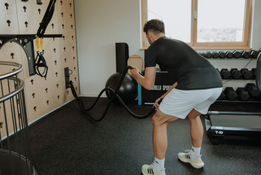 PhysJO - Patient im Fitnessraum mit Kurzhanteln