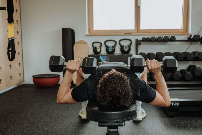 Patient im Fitnessraum mit Kurzhanteln